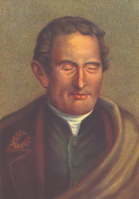 A imagem é uma pintura do retrato de Louis Braille que era um homem branco, com cabelo curto e castanho. Está vestindo uma capa, debaixo tem um terno verde e dentro uma camisa branca.